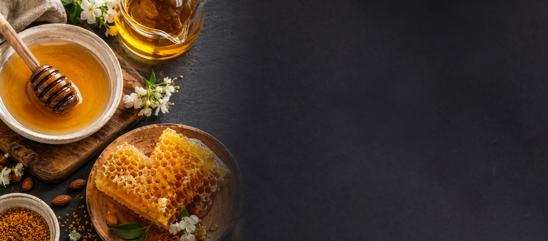 Miel doré en nid d'abeille et en pot, avec des amandes et des fleurs blanches