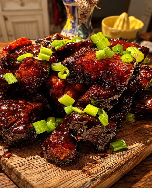 Cubes de viande style « burnt ends » au miel, garnis de ciboulette fraîche.
