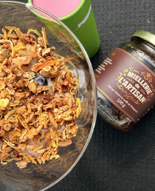 Bol de granola avec lait, miel à la vanille de Madagascar et tasse verte